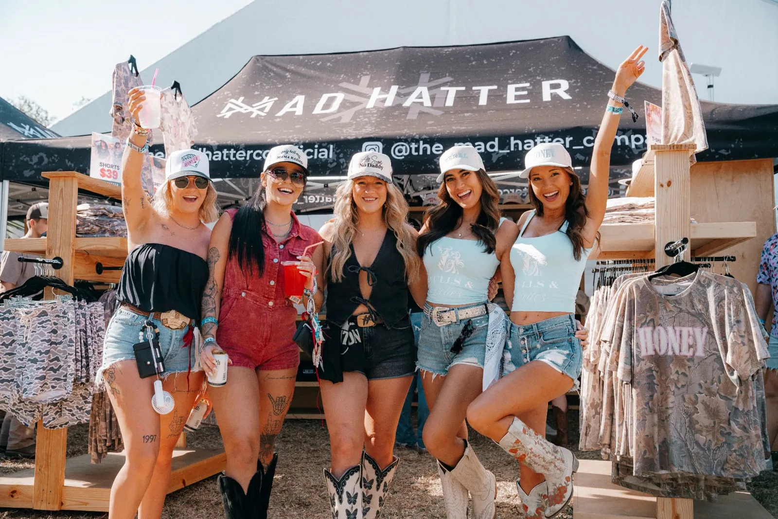 Fans in branded hats at the Mad Hatter booth, event sponsorship activation