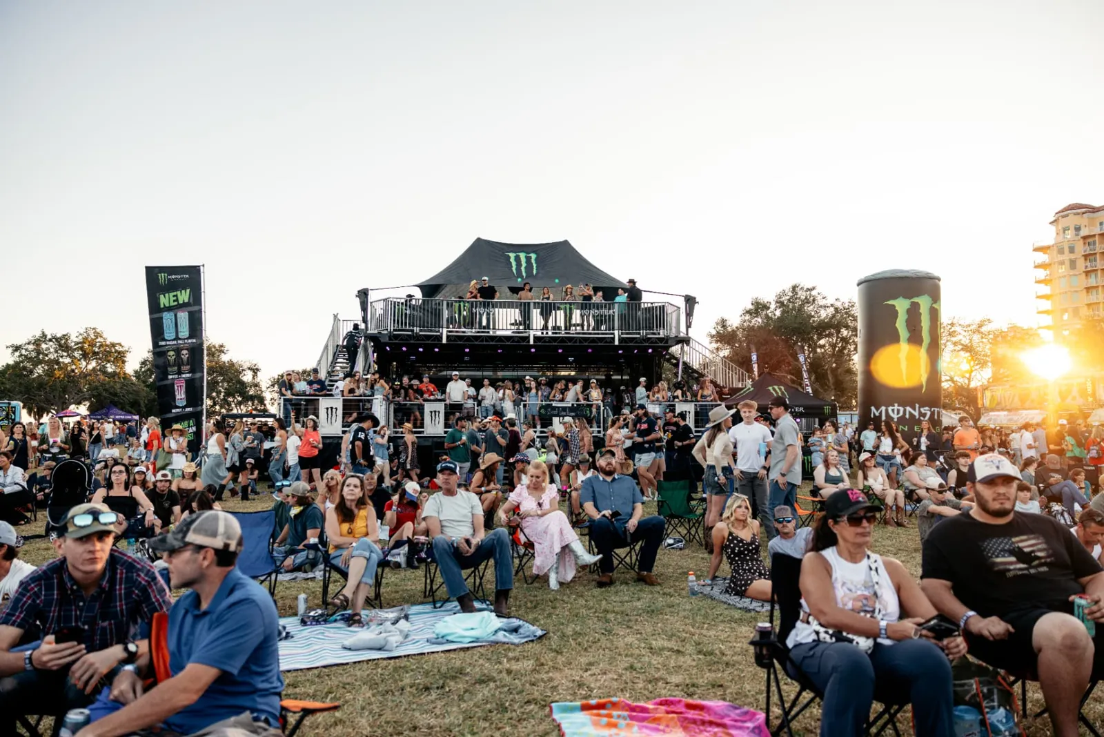 Crowd on the lawn with Monster Energy branding, festival sponsorship