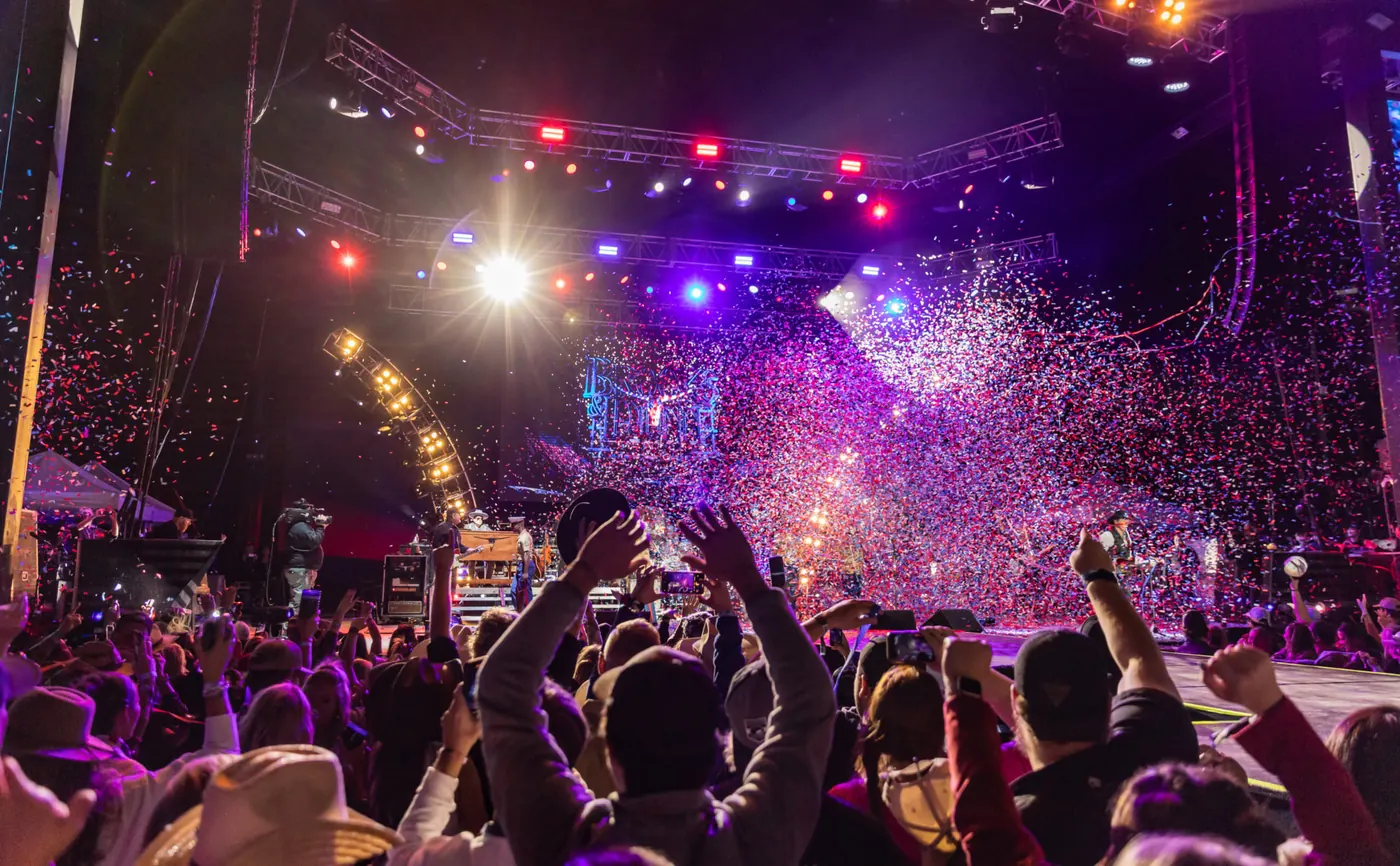 Festival crowd cheering near the stage, event sponsorship reach