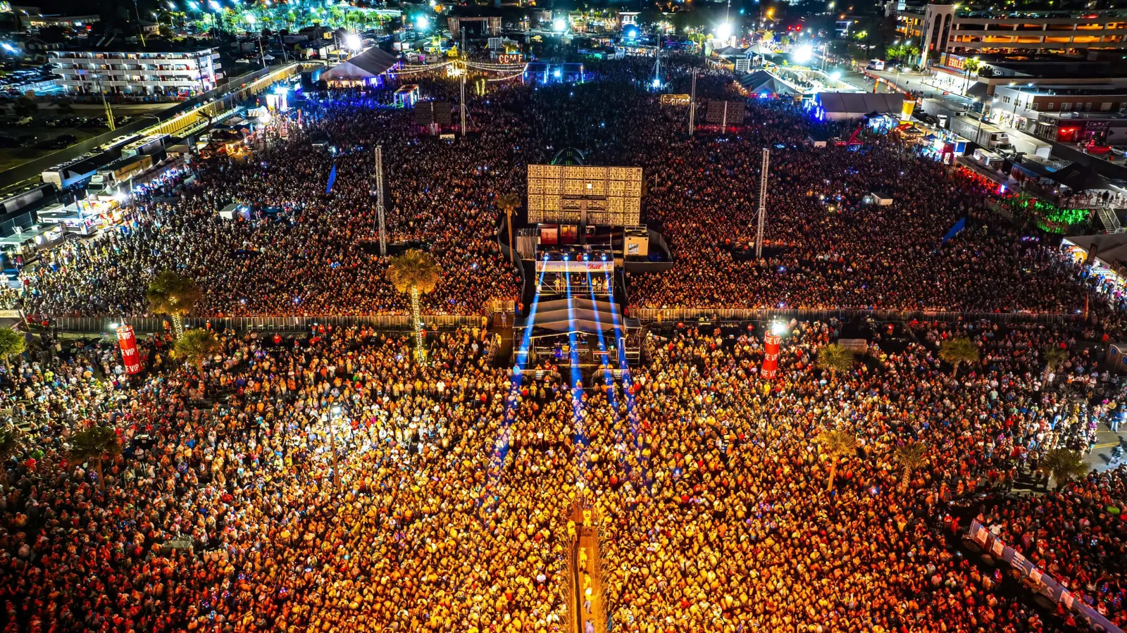 Daytime drone view of festival grounds with event sponsorship footprints