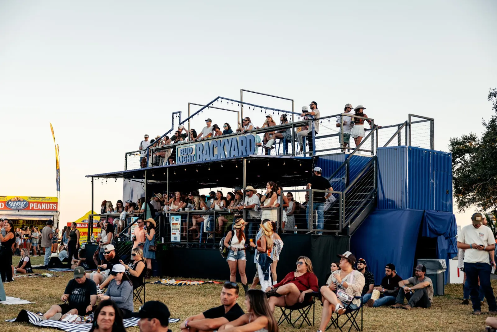 Two-level branded VIP deck packed with fans, a festival brand experience